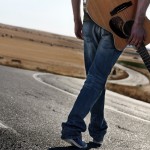 Mann mit Jeans und Gitarre auf der Strasse